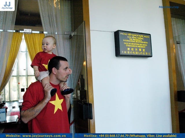 A father and his child are visiting Independence Palace and they look very cute.
